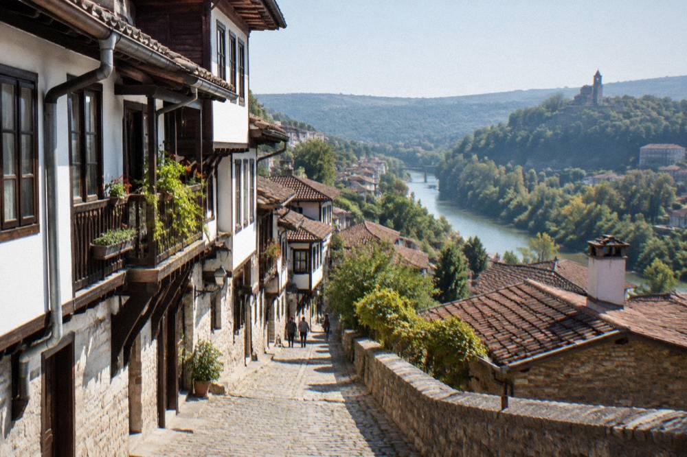 A cobblestone revival street with traditional houses above a river gorge