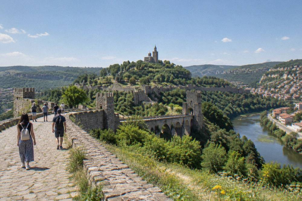 Visitors walking the ramparts of Tsarevets Fortress on a bright afternoon