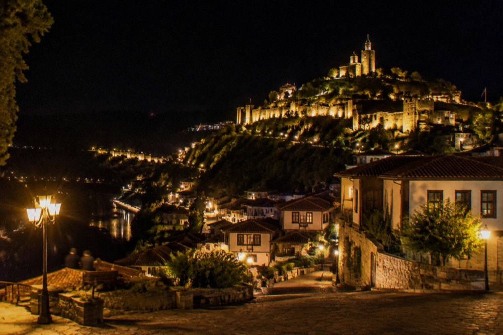 Illuminated fortress hill seen from a city square at night