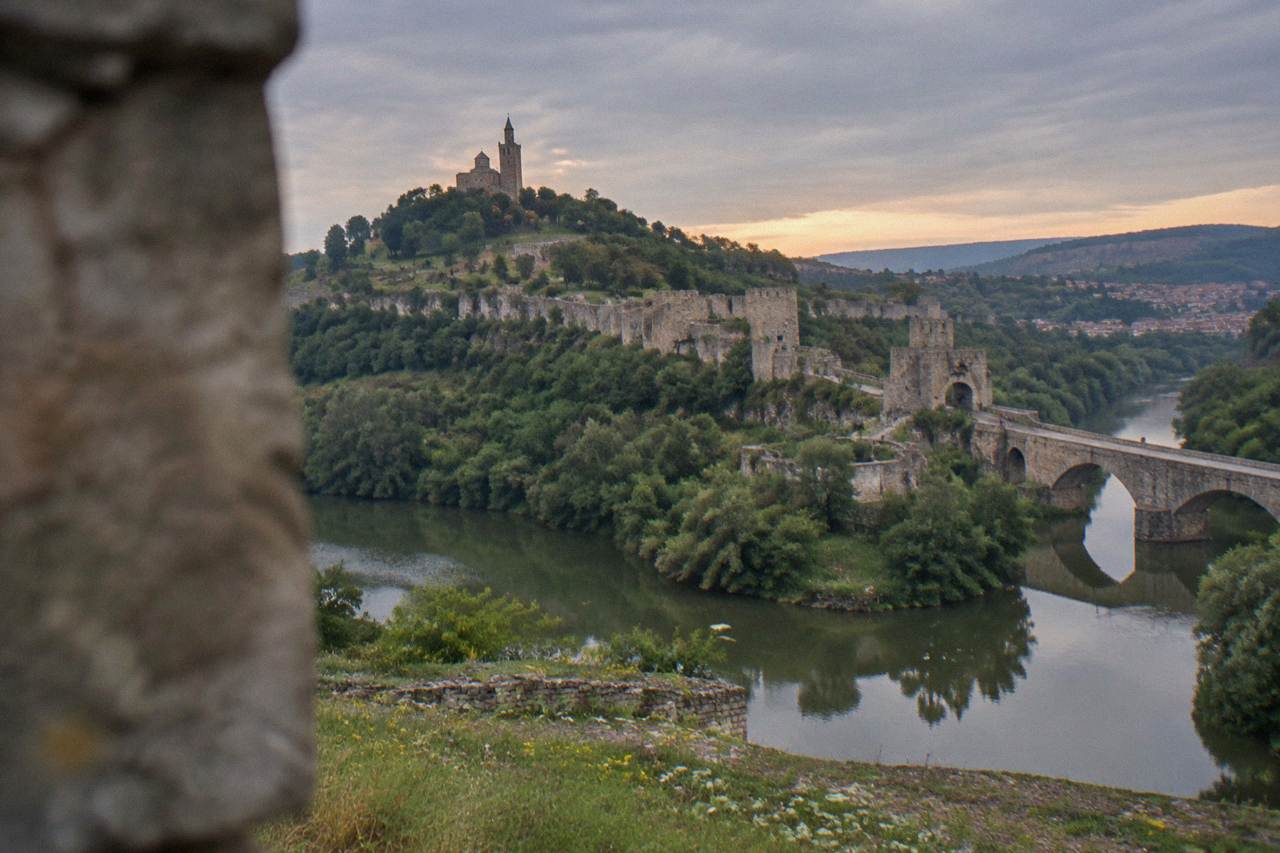 Tsarevets Fortress hill rising above the Yantra river at dusk in Veliko Tarnovo