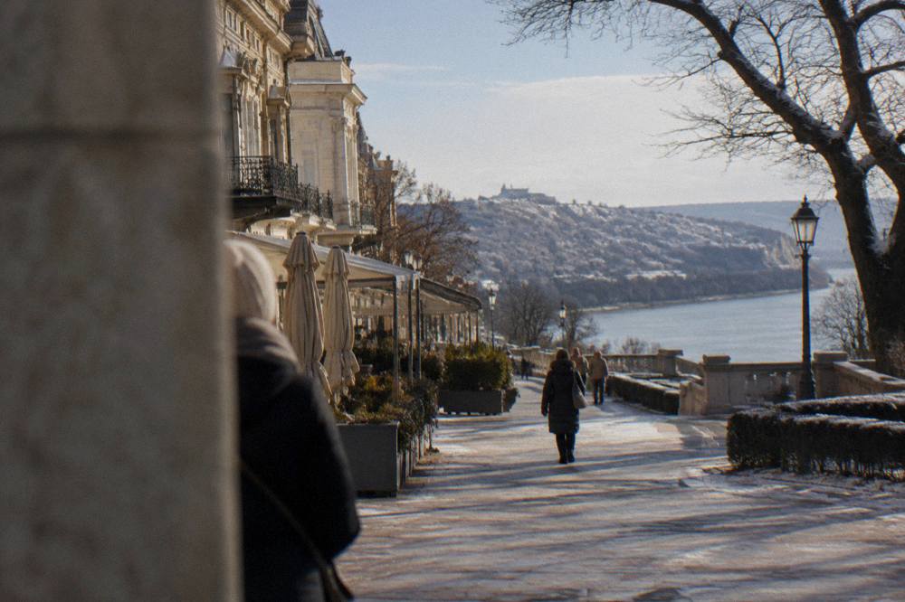 A snow-dusted hilltop town with a river winding below in winter light