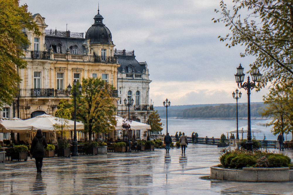 A grand European city square with ornate buildings beside a wide river