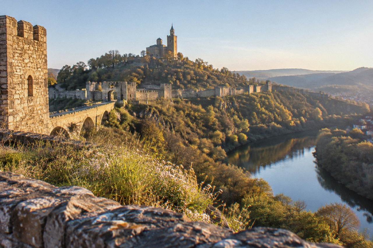 Tsarevets Fortress hill rising above the Yantra river at golden hour in Veliko Tarnovo