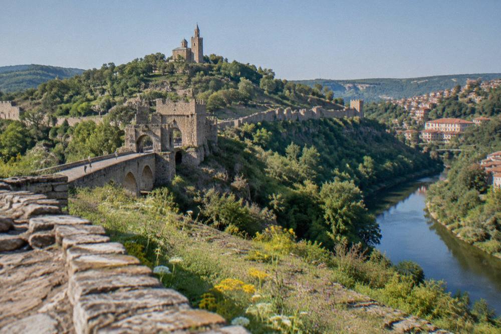 Stone fortification walls along the ridge of the Tsarevets fortress hill under a clear sky