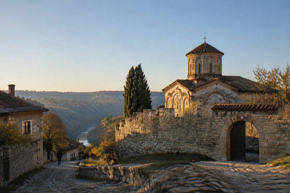 The fortified stone walls of a medieval church in the village of Arbanasi under a clear sky