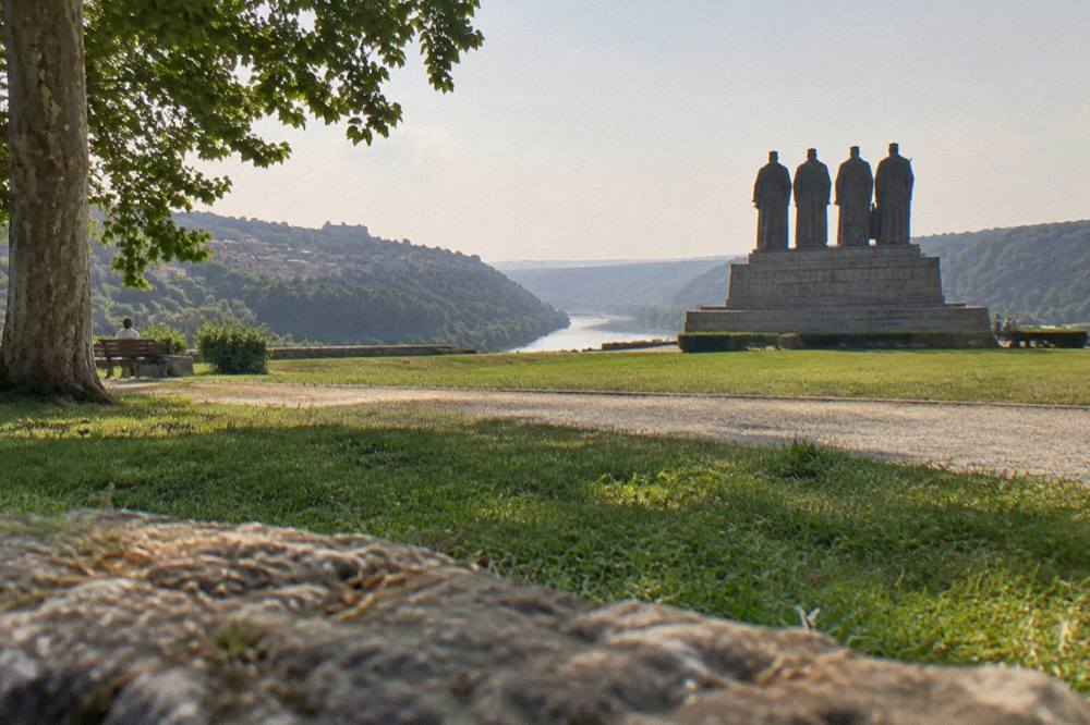 The Asenevtsi Monument of four medieval kings silhouetted against the evening sky above the Yantra river
