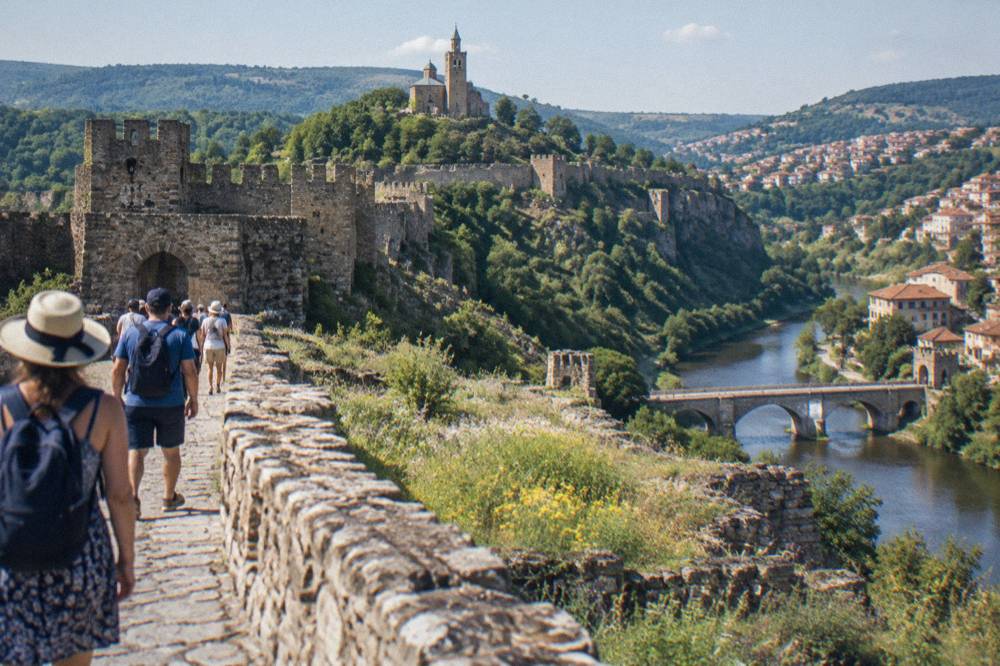 Tour group walking along the fortress walls of Tsarevets on a sunny afternoon