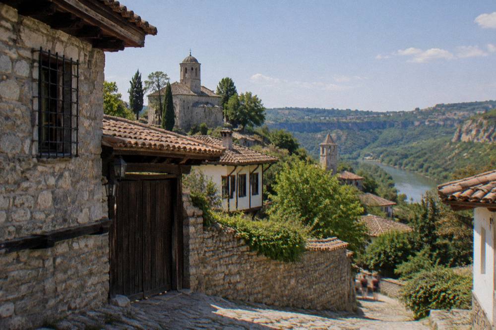 Stone houses and church towers of Arbanasi village above a green valley