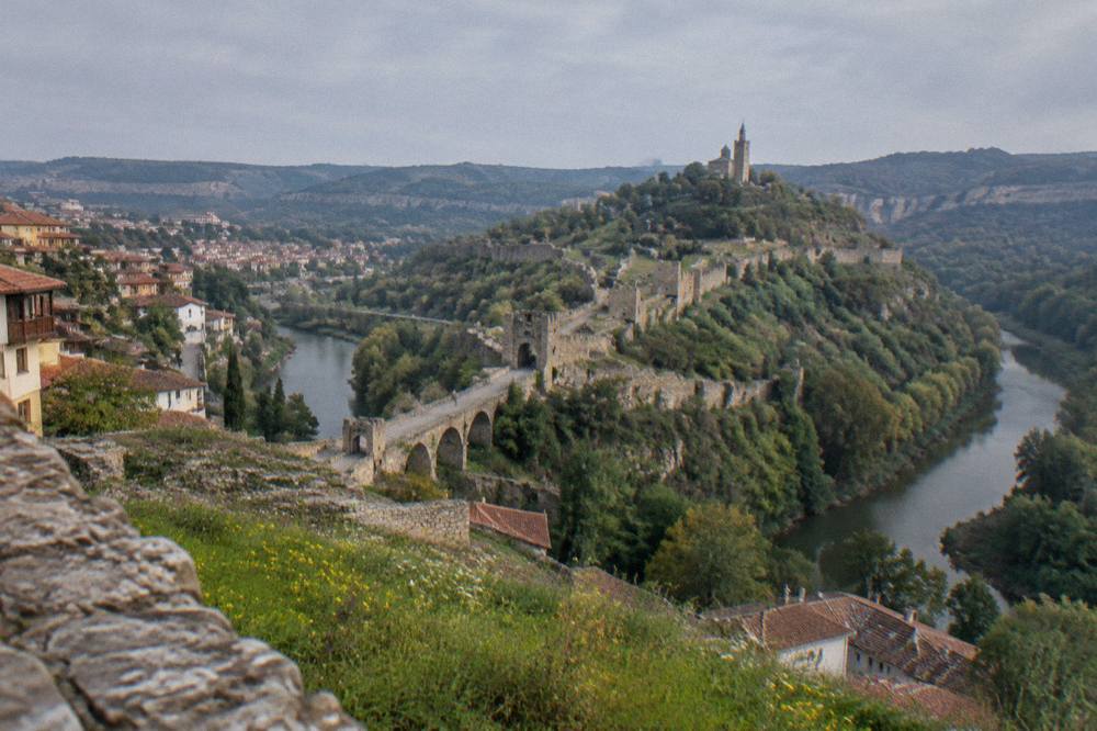 The walled hill of Tsarevets fortress rising above rooftops in Veliko Tarnovo